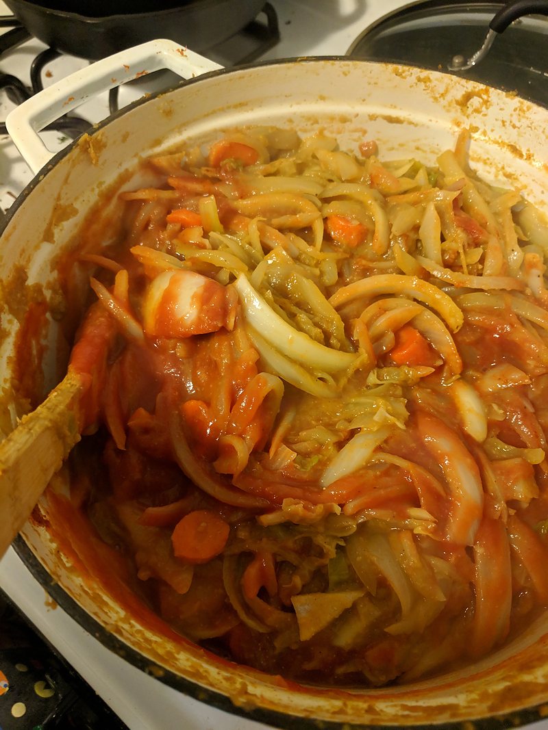 Onions, carrots and peppers cooking down in a pot